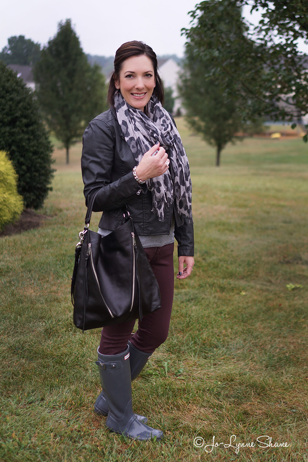 Fall Fashion for Women Over 40: Rain boots with plum skinny jeans, grey animal print scarf and moto jacket