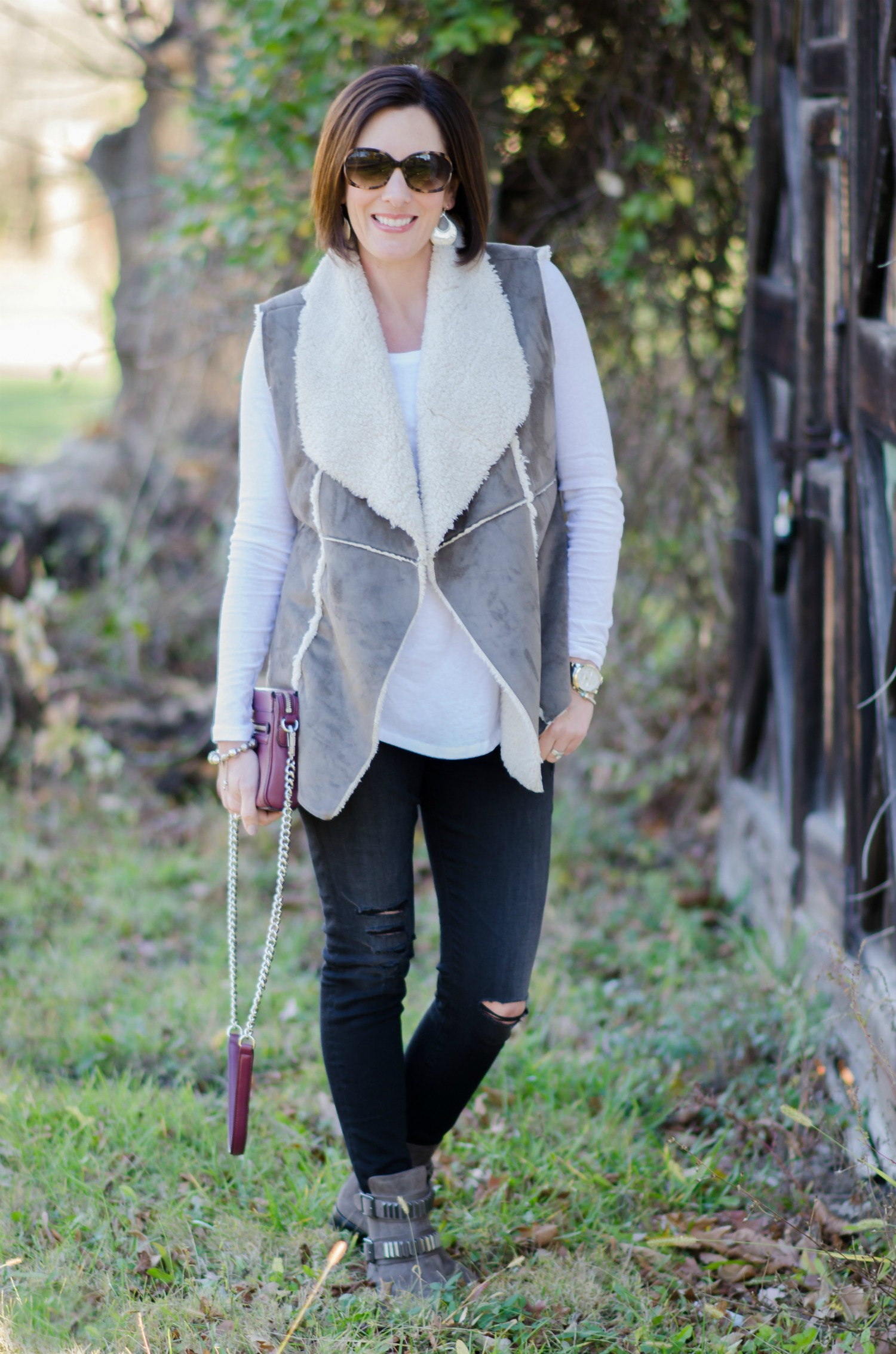 Winter Outfit Idea: Shearling Vest + White Tee with Destructed Jeans and Moto Boots