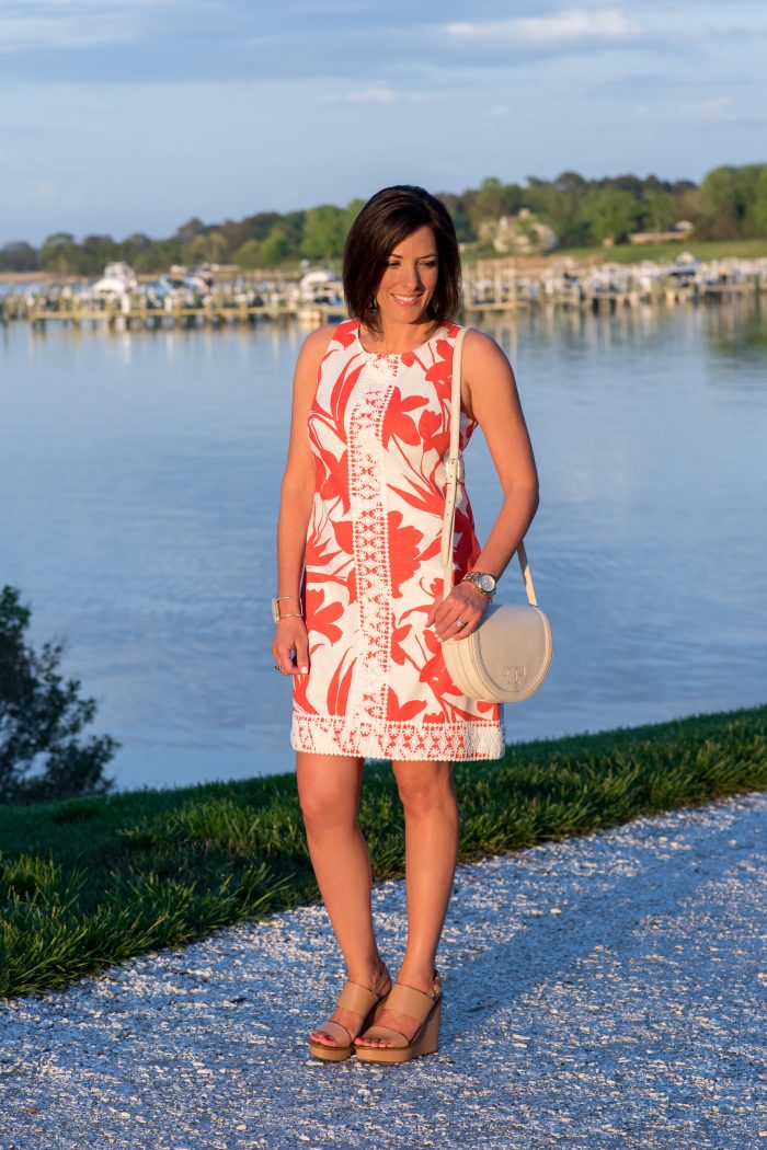 This bright coral and white floral sleeveless shift dress with crochet lace detail is a summer classic. Dress it up with wedge sandals or down with flats.