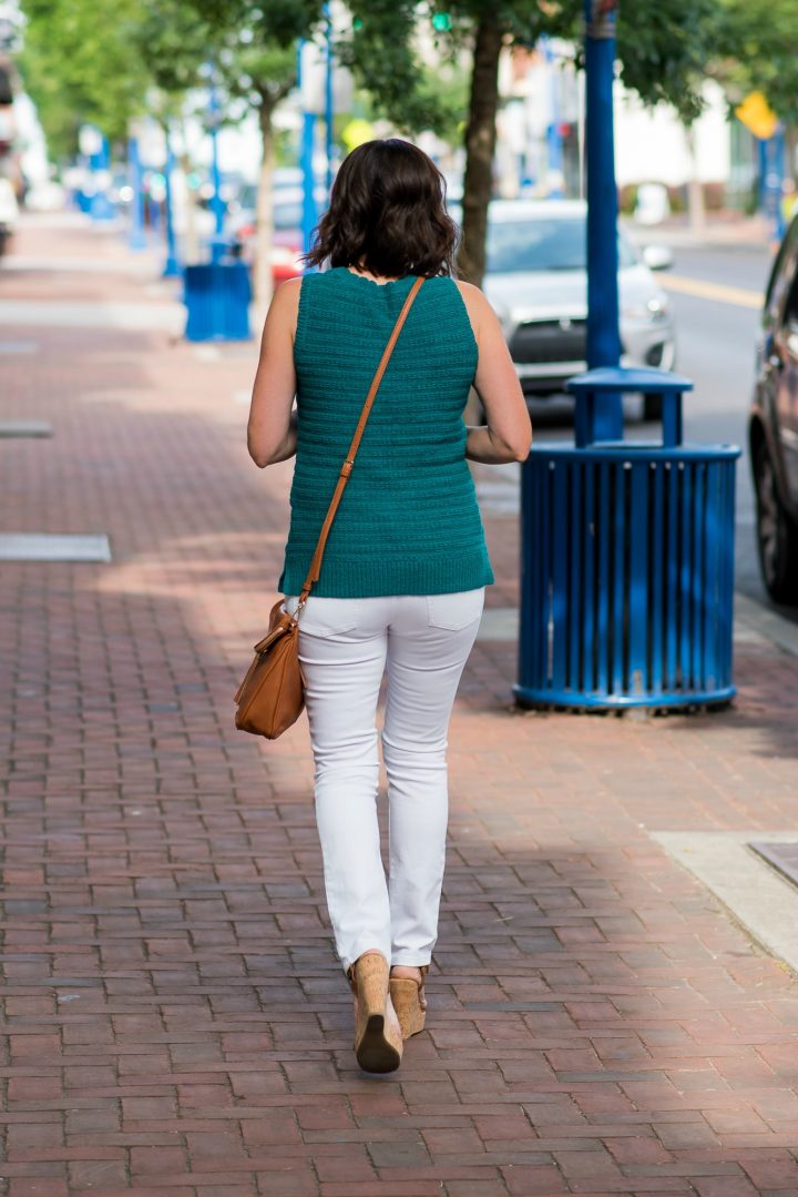 This gorgeous teal sleeveless sweater outfit with white jeans and cognac accessories is perfect for summer, and the sweater is also a great transition piece for fall.