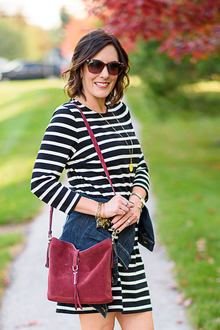 How to Wear a Black and White Striped Dress Outfit for Fall: with a denim jacket and burgundy bucket bag