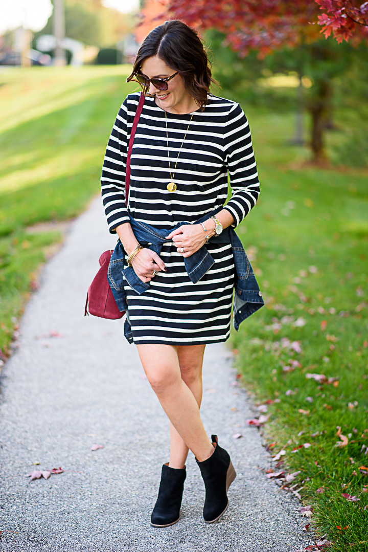 How to Wear a Black and White Striped Dress Outfit for Fall: with black ankle boots, denim jacket, and burgundy bucket bag