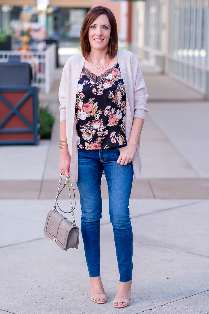 Jo-Lynne Shane wearing a fall outfit with a floral cami, beige cashmere cocoon cardigan, AG legging ankle jeans, and suede ankle strap sandals.