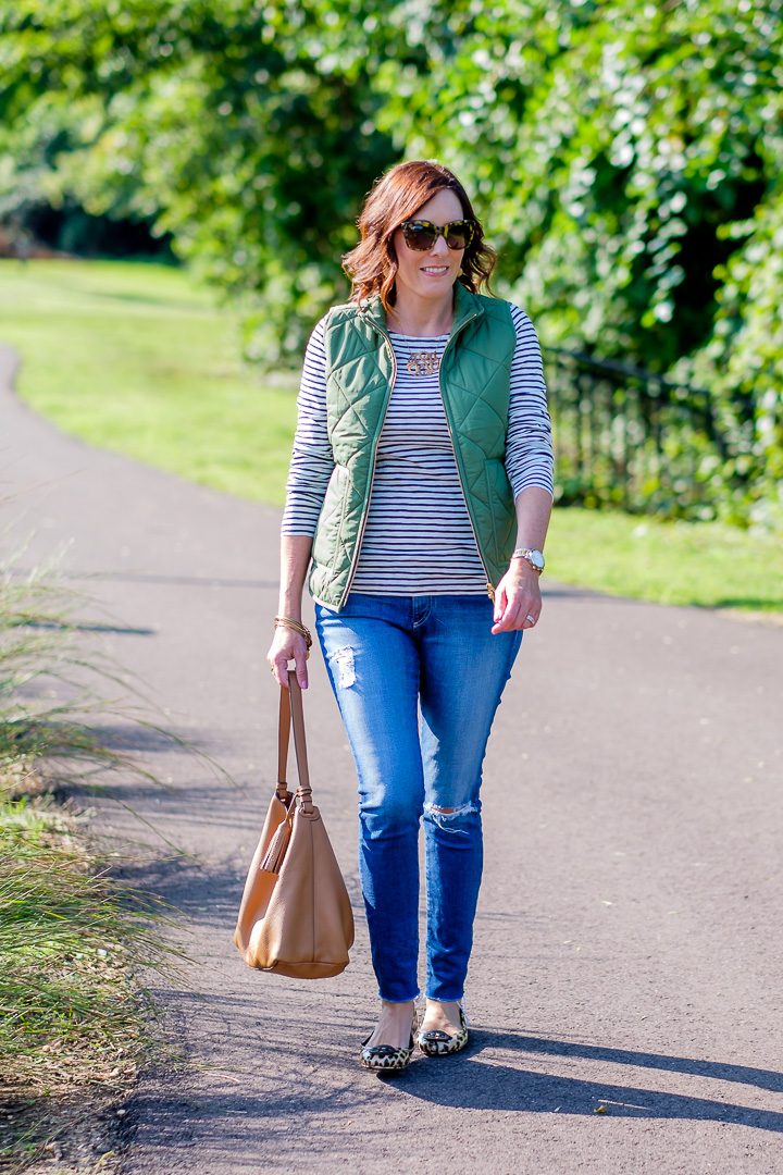 Jo-Lynne Shane wearing green J. Crew Mercantile Women's Puffer Vest, Long-sleeve striped artist T-shirt, AG Raw Hem The Legging Ankle Jeans, and Tory Burch Minnie travel ballet flats in leopard print patent leather, with Love Always Classic Monogram Necklace 3XL in gold dipped. #fashion #womensfashion #puffervest #jcrewmercantile #fashionover40