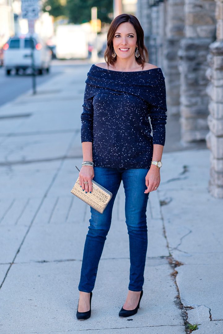 Jo-Lynne Shane wearing a casual fall off-the-shoulder sweater outfit with a navy flecked off-the-shoulder sweater, AG Farrah skinny jeans, and black suede pumps. #falloutfit #offtheshouldertrend