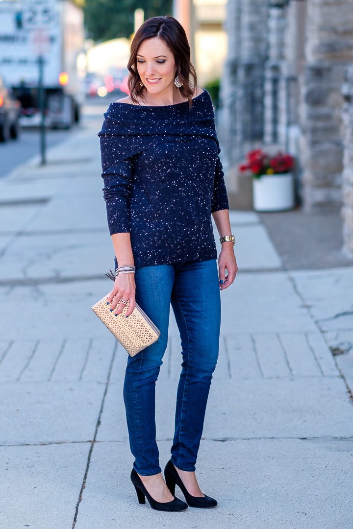 Jo-Lynne Shane wearing a casual fall off-the-shoulder sweater outfit with a navy flecked off-the-shoulder sweater, AG Farrah skinny jeans, and black suede pumps. #falloutfit #offtheshouldertrend