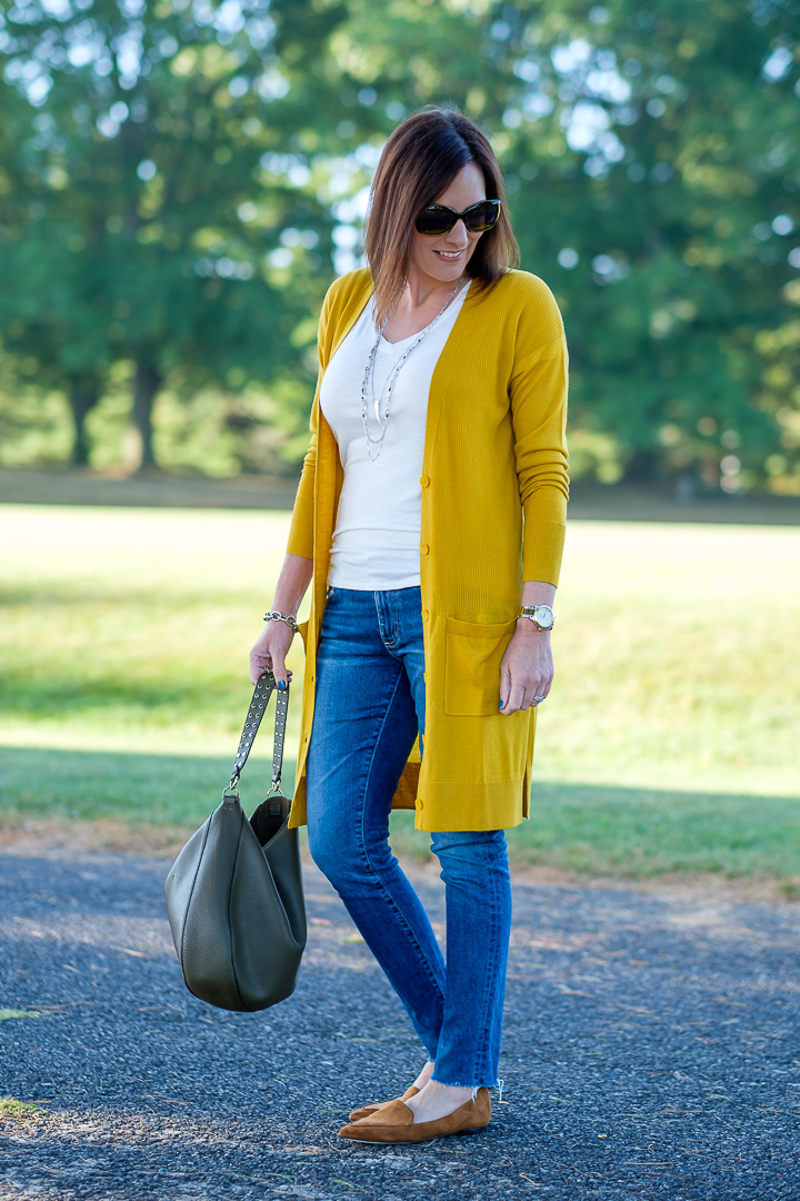 Jo-Lynne Shane wearing a mustard cardigan outfit with moss green bag and cognac loafers.