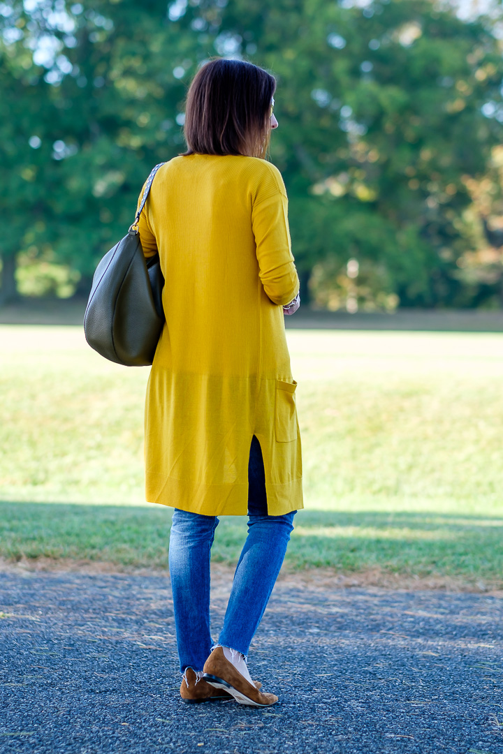 Jo-Lynne Shane wearing a long mustard cardigan with moss green bag and cognac loafers. #falloutfit #mustardcardigan