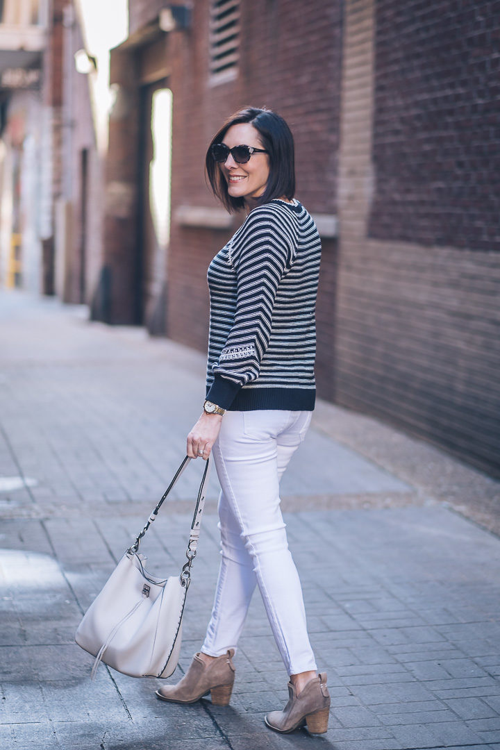 Jo-Lynne Shane wearing Loft striped whipstitched sweater, ultra white Paige Verdugo ankle skinny jeans, Vince Camuto booties, and R Minkoff Darren shoulder bag with Maui Jim Moonbow sunnies. #momstyle #springfashion