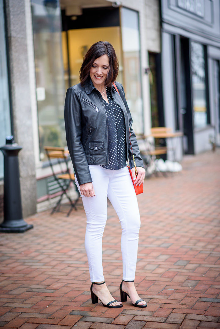 Spring Outfit: Bernardo Front Zip Leather Moto Jacket over Vince Camuto Poetic Dots Sleeveless V-Neck Blouse in Rich Black with white Topshop Jamie high waist skinny ankle jeans and Stuart Weitzman NearlyNude Ankle Strap Sandals in Black Nappa