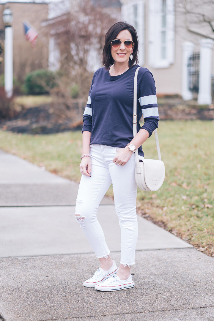 A weekend ready look for spring featuring Treasure&Bond navy varsity tee, J.Brand white distressed cropped jeans, and Converse Shoreline slip-on sneakers. #springfashion #fashionover40