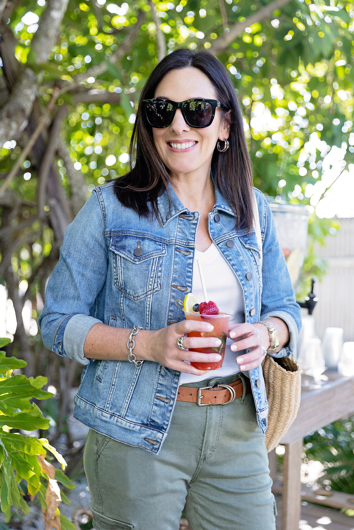 Jo-Lynne Shane wearing KUT from the Kloth Jacqueline denim jacket with YSL sunglasses and holding a strawberry basil lemonade in Florida